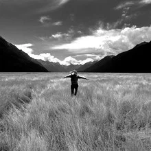 Photo art by Julian November: girl running through a wide field in New Zealand