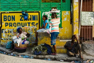 Street scene in Port aux Prince: people at a market in front of colorful walls