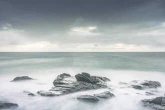 Pastel-colored coastal landscape in Norway, gentle waves create a calm atmosphere.