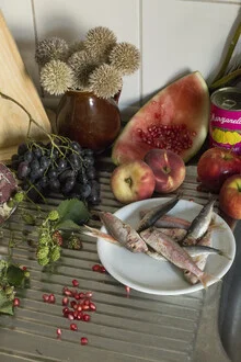 Still life featuring fruit and fish, soft colors, calm atmosphere.