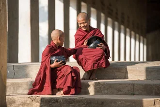 Two monks in Myanmar with rice bowls, soft colors and a peaceful atmosphere