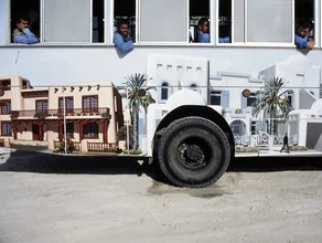 Photo art by Florian Büttner: Bus on the street in Dubai, with workers in the background.