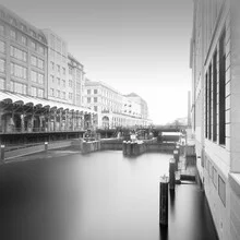 Cityscape of Hamburg featuring Alsterarkaden and calm waters.
