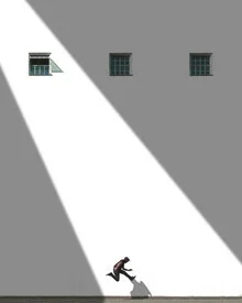 Mann springt vor einem weißen Wand mit Schatten und Fenstern in Chile.
