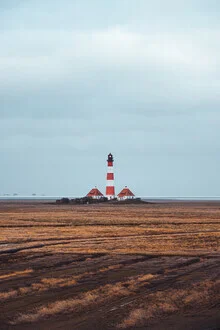 Fotokunst von Lars Brauer: Leuchtturm im Wind, umgeben von Wolken und einem ruhigen Wattenmeer