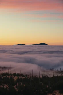 Photo art by Florian Eichinger: fog envelops majestic mountains at sunset.