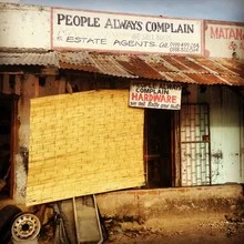 Humorous shop sign in Malawi, conveying a cheerful atmosphere.