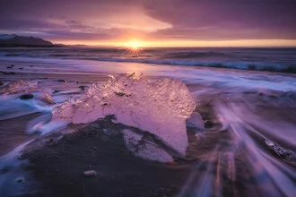 Photo art by Jean Claude Castor: Ice chunks on black sand beach at sunrise